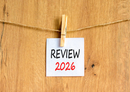 Review 2026 symbol. Concept words Review 2026 on beautiful white paper on wooden clothespin....