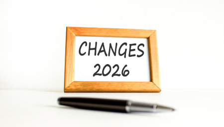 Changes 2026 symbol. Concept words Changes 2026 on beautiful wooden picture frame. Beautiful white paper background. Beautiful black pen. Business and changes 2026 concept. Copy space.の写真素材