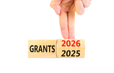 2026 Grants symbol. Concept words 2026 Grants on beautiful wooden blocks. Beautiful white paper background. Businessman's hand. Business and 2026 grants concept. Copy space.の写真素材