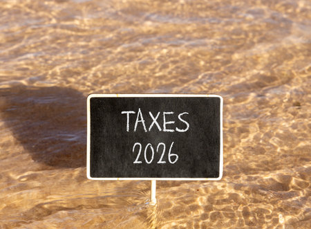 Taxes 2026 new year symbol. Concept words Taxes 2026 on beautiful black blackboard. Beautiful Red...