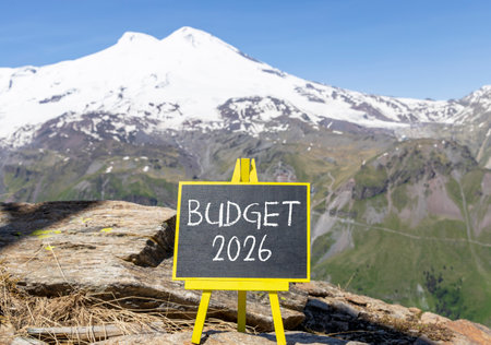 Budget 2026 symbol. Concept words Budget 2026 on beautiful black blackboard. Beautiful mountain Elbrus and blue sky background. Business and budget 2026 concept. Copy space.の写真素材