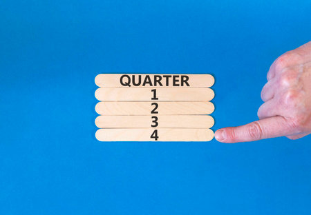 4th fourth quarter 4 symbol. Concept word Quarter 4 on beautiful wooden sticks. Beautiful blue background. Businessman's hand. Business, happy 4th fourth quarter 4 Q4 concept. Copy space.の写真素材