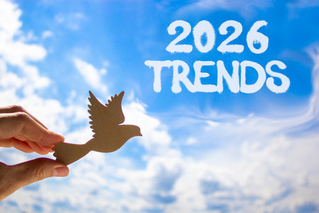 2026 Trends new year symbol. Concept words 2026 Trends on beautiful blue sky. Beautiful blue sky background. Businessman's hand holds wooden bird. Business and 2026 Trends new year concept. Copy spaceの写真素材