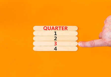 3rd third quarter 3 symbol. Concept word Quarter 3 on beautiful wooden sticks. Beautiful orange background. Businessman's hand. Business, happy 3rd quarter 3 Q3 concept. Copy space.の写真素材