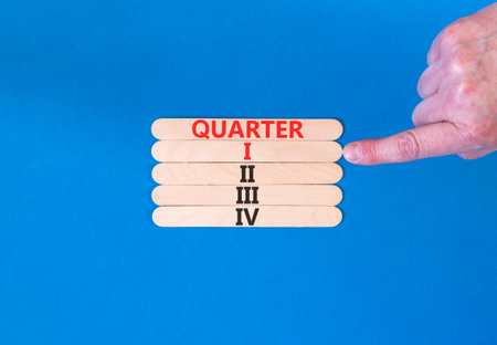 1st first quarter 1 symbol. Concept word Quarter 1 on beautiful wooden sticks. Beautiful blue background. Businessman's hand. Business, happy 1st first quarter 1 Q1 concept. Copy space.の写真素材