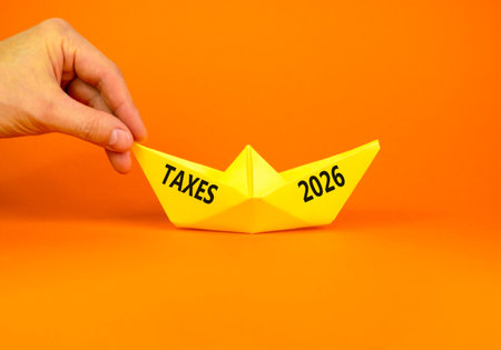 Taxes 2026 new year symbol. Concept words Taxes 2026 on beautiful yellow paper boat. Beautiful...
