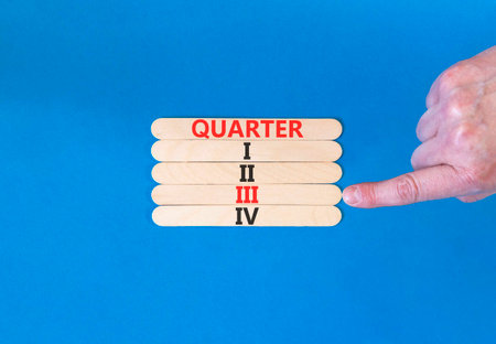 3rd third quarter 3 symbol. Concept word Quarter 3 on beautiful wooden sticks. Beautiful blue background. Businessman's hand. Business, happy 3rd quarter 3 Q3 concept. Copy space.の写真素材