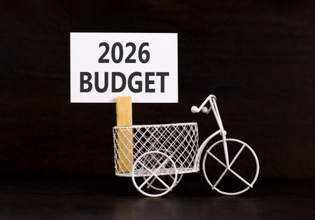 2026 Budget symbol. Concept words 2026 Budget on beautiful white paper on wooden clothespin. Beautiful black background. Beautiful miniature bicycle. Business and 2026 budget concept. Copy space.の写真素材