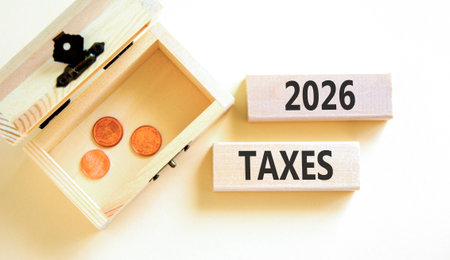 2026 taxes new year symbol. Concept words 2026 taxes on beautiful wooden blocks. Beautiful white paper background. Beautiful wooden chest with coins. Business 2026 taxes new year concept. Copy space.の写真素材