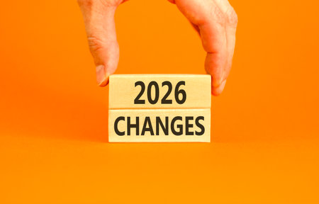 2026 Changes symbol. Concept words 2026 Changes on beautiful wooden blocks. Beautiful orange paper background. Businessman's hand. Business and 2026 changes concept. Copy space.の写真素材