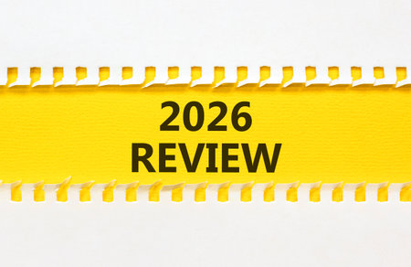2026 Review symbol. Concept words 2026 Review on beautiful yellow paper. Beautiful white paper background. Business and 2026 review concept. Copy space.の写真素材