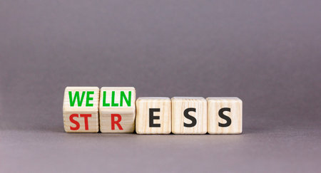 Wellness or stress symbol. Concept words Wellness or Stress on beautiful wooden cubes. Beautiful...
