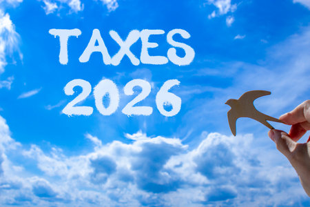 Taxes 2026 new year symbol. Concept words Taxes 2026 on beautiful blue sky. Beautiful blue sky background. Businessman's hand holds wooden bird. Business and taxes 2026 new year concept. Copy space.の写真素材