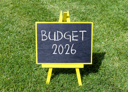 Budget 2026 symbol. Concept words Budget 2026 on beautiful black blackboard. Beautiful green grass...