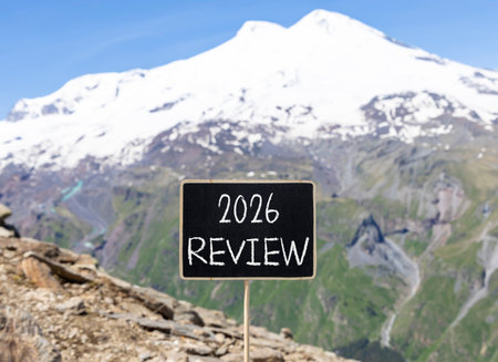 2026 Review symbol. Concept words 2026 Review on beautiful black blackboard. Beautiful mountain Elbrus and blue sky background. Business and 2026 review concept. Copy space.の写真素材