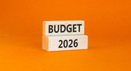 Budget 2026 symbol. Concept words Budget 2026 on beautiful wooden blocks. Beautiful orange paper background. Business and budget 2026 concept. Copy space.の写真素材