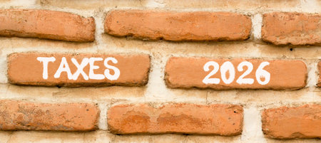 Taxes 2026 new year symbol. Concept words Taxes 2026 on beautiful brown brick wall. Beautiful brown brick wall background. Business and taxes 2026 new year concept. Copy space.の写真素材