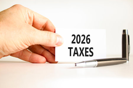 2026 taxes new year symbol. Concept words 2026 taxes on beautiful white card. Beautiful white paper background. Businessman's hand. Business and 2026 taxes new year concept. Copy space.の写真素材