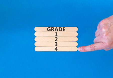Time to grade 4 symbol. Concept word Grade 1 2 3 4 on beautiful wooden sticks. Businessman's hand....