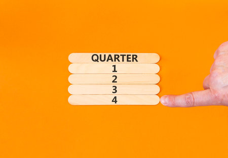 4th fourth quarter 4 symbol. Concept word Quarter 4 on beautiful wooden sticks. Beautiful orange background. Businessman's hand. Business, happy 4th fourth quarter 4 Q4 concept. Copy space.の写真素材