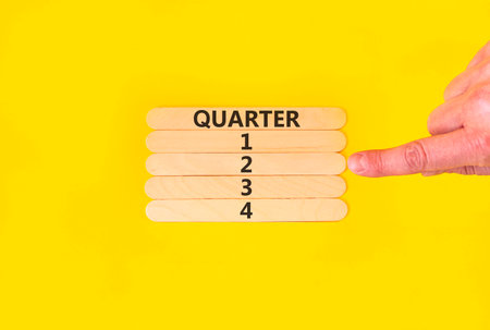 2nd second quarter 2 symbol. Concept word Quarter 2 on beautiful wooden sticks. Beautiful yellow background. Businessman's hand. Business, happy 2nd second quarter 2 Q2 concept. Copy space.の写真素材