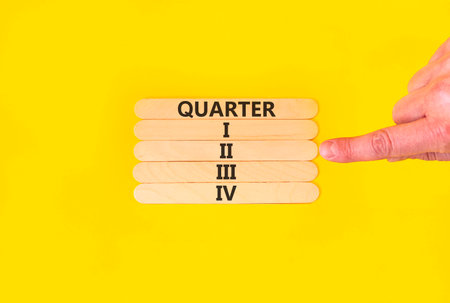 2nd second quarter 2 symbol. Concept word Quarter 2 on beautiful wooden sticks. Beautiful yellow background. Businessman's hand. Business, happy 2nd second quarter 2 Q2 concept. Copy space.の写真素材