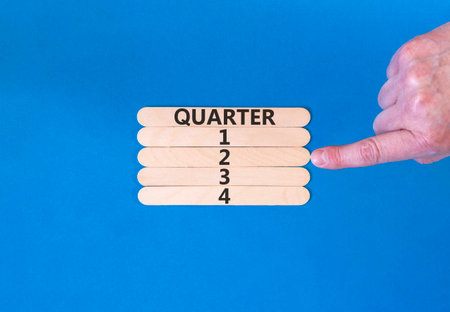 2nd second quarter 2 symbol. Concept word Quarter 2 on beautiful wooden sticks. Beautiful blue background. Businessman's hand. Business, happy 2nd second quarter 2 Q2 concept. Copy space.の写真素材