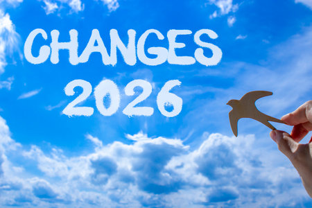 Changes 2026 symbol. Concept words Changes 2026 on beautiful blue sky. Beautiful blue sky background. Businessman's hand holds wooden bird. Business and changes 2026 concept. Copy space.の写真素材