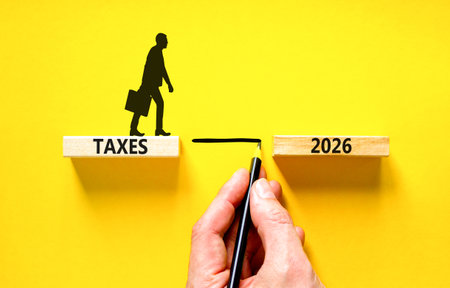 Taxes 2026 symbol. Concept words Taxes 2026 on beautiful wooden blocks. Beautiful yellow background....