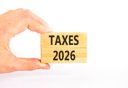 Taxes 2026 new year symbol. Concept words Taxes 2026 on beautiful wooden blocks. Beautiful white...