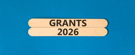 Grants 2026 symbol. Concept words Grants 2026 on beautiful wooden sticks. Beautiful blue paper background. Business and grants 2026 concept. Copy space.の写真素材