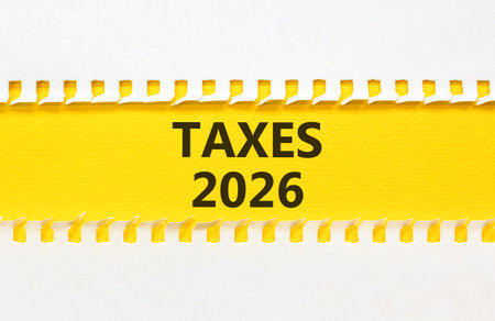 Taxes 2026 new year symbol. Concept words Taxes 2026 on beautiful yellow paper. Beautiful white paper background. Business and taxes 2026 new year concept. Copy space.の写真素材