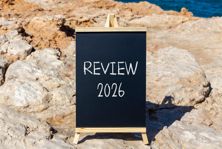 Review 2026 symbol. Concept words Review 2026 on beautiful black blackboard. Beautiful stone and...