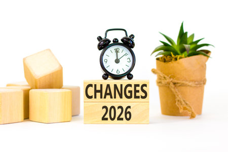 Changes 2026 symbol. Concept words Changes 2026 on beautiful wooden blocks. Beautiful white paper background. Beautiful black alarm clock. Business and changes 2026 concept. Copy space.の写真素材