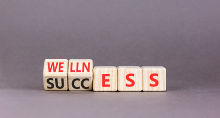 Wellness and success symbol. Concept words Wellness and Success on beautiful wooden cubes. Beautiful gray background. Business, psychological wellness and success concept. Copy space.の写真素材