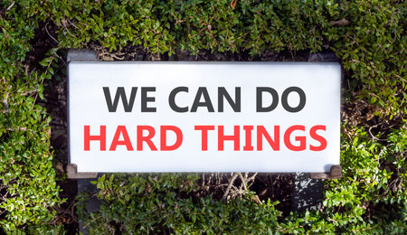 Support, help we can do hard things symbol. Concept words We can do hard things on white beautiful road sign. Beautiful green trees background. Business we can do hard things concept. Copy space.の写真素材