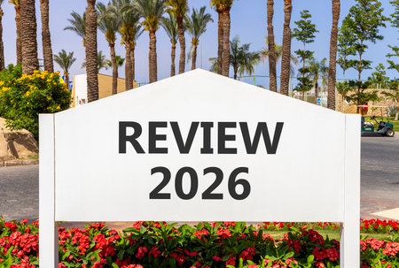 Review 2026 symbol. Concept words Review 2026 on beautiful white road sign. Beautiful palm trees palm-trees and blue sky background. Business and review 2026 concept. Copy space.の写真素材