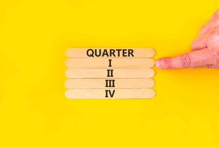 1st first quarter 1 symbol. Concept word Quarter 1 on beautiful wooden sticks. Beautiful yellow background. Businessman's hand. Business, happy 1st first quarter 1 Q1 concept. Copy space.の写真素材