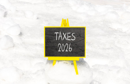 Taxes 2026 new year symbol. Concept words Taxes 2026 on beautiful black blackboard. Beautiful white snow background. Business and taxes 2026 new year concept. Copy space.の写真素材