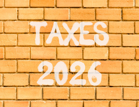 Taxes 2026 new year symbol. Concept words Taxes 2026 on beautiful old brown brick wall. Beautiful old brown brick wall background. Business and taxes 2026 new year concept. Copy space.の写真素材