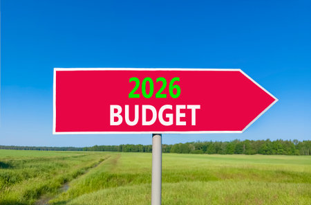 2026 Budget symbol. Concept words 2026 Budget on beautiful red road sign. Beautiful green grass field forest and blue sky background. Business and 2026 budget concept. Copy space.の写真素材