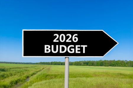 2026 Budget symbol. Concept words 2026 Budget on beautiful black road sign. Beautiful green grass field forest and blue sky background. Business and 2026 budget concept. Copy space.の写真素材