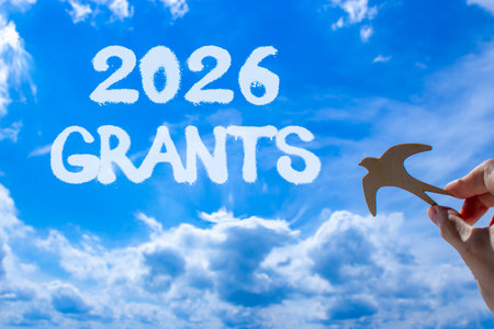 2026 Grants symbol. Concept words 2026 Grants on beautiful blue sky. Beautiful blue sky background. Businessman's hand holds wooden bird. Business and 2026 grants concept. Copy space.の写真素材