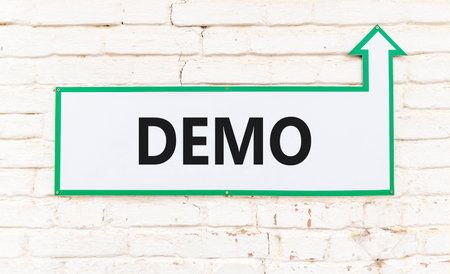 Demo symbol. Concept word Demo on beautiful white sign on old white brick wall. Beautiful brick old...