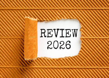 Review 2026 symbol. Concept words Review 2026 on beautiful white paper. Beautiful brown paper...