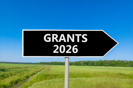 Grants 2026 symbol. Concept words Grants 2026 on beautiful black road sign. Beautiful green grass...