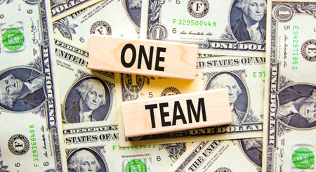 One team symbol. Concept word One team on beautiful wooden blocks. Dollar bills. Beautiful dollar...