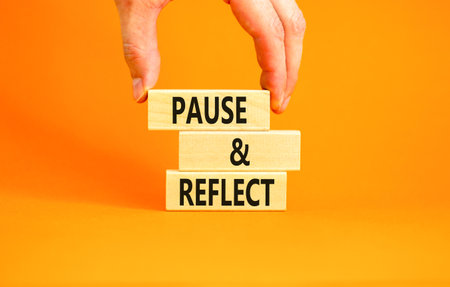 Pause and reflect symbol. Concept words Pause and reflect on beautiful block. Businessman's hand. Beautiful orange background. Business motivational lifestyle pause and reflect concept. Copy space.の写真素材
