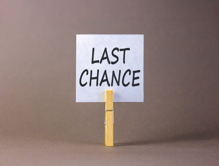 Last chance symbol. Concept word Last chance on beautiful white paper. Beautiful wooden clothespin. Beautiful gray background. Business last chance concept. Copy space.の写真素材