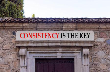 Consistency is the key symbol. Concept words Consistency is the key on beautiful white marble sign plate. Beautiful stone wall background. Business consistency is the key concept. Copy space.の写真素材